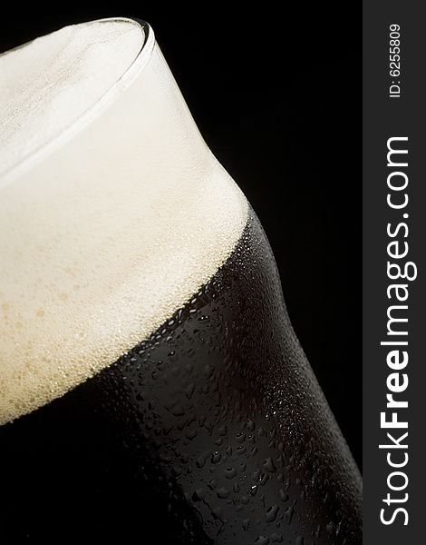 Close-up of dark beer isolated on a black background