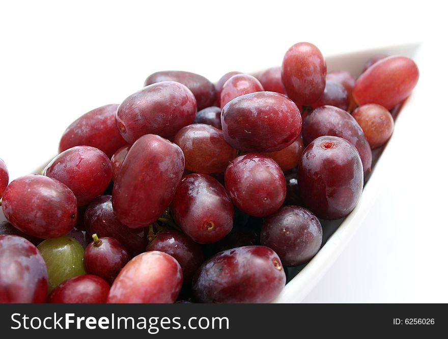 Some red grapes in beautiful table-ware