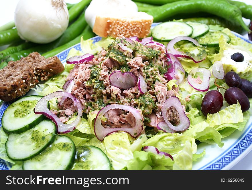 A fresh salad with fish, onions and cucumbers