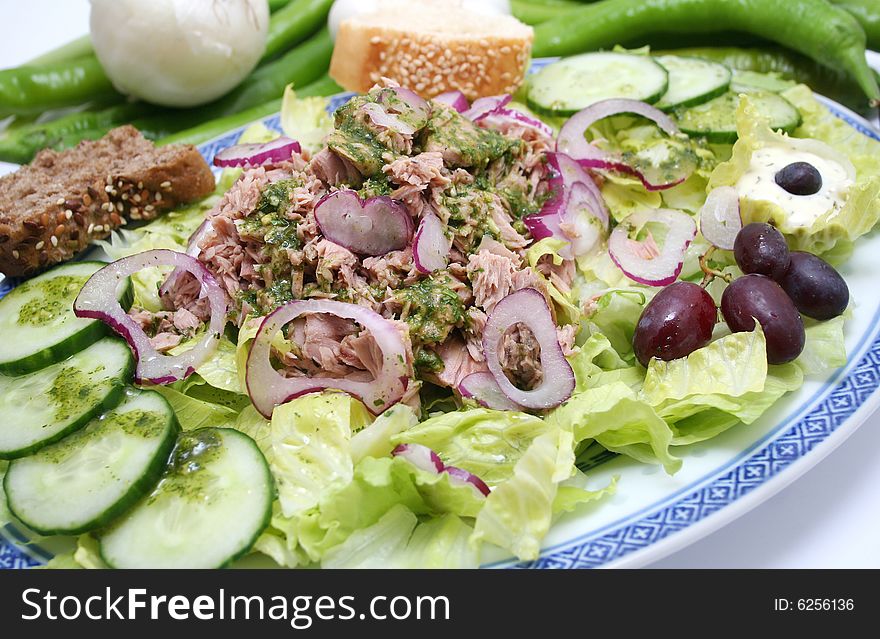 A fresh salad with fish, onions and cucumbers