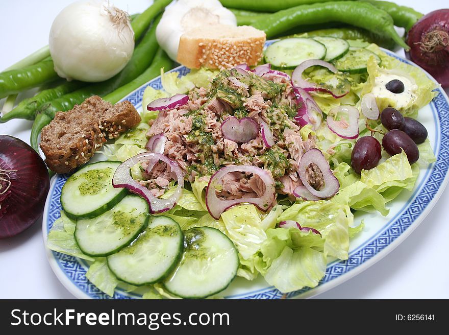 A fresh salad with fish, onions and cucumbers