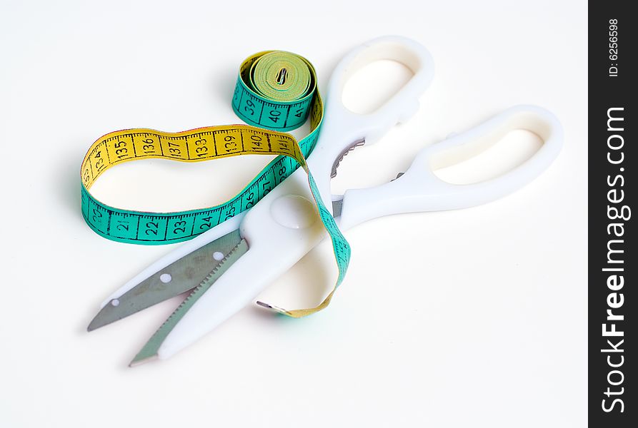Scissors and length measurer at white background. Scissors and length measurer at white background