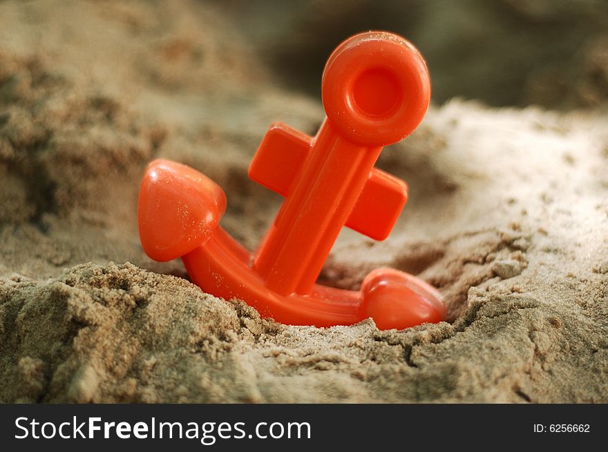 Toy anchor in a sand beach