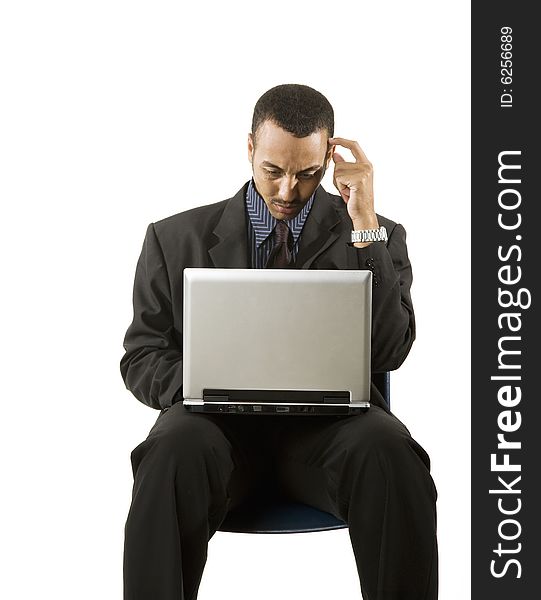 A young professional African-American male working on a laptop. A young professional African-American male working on a laptop.