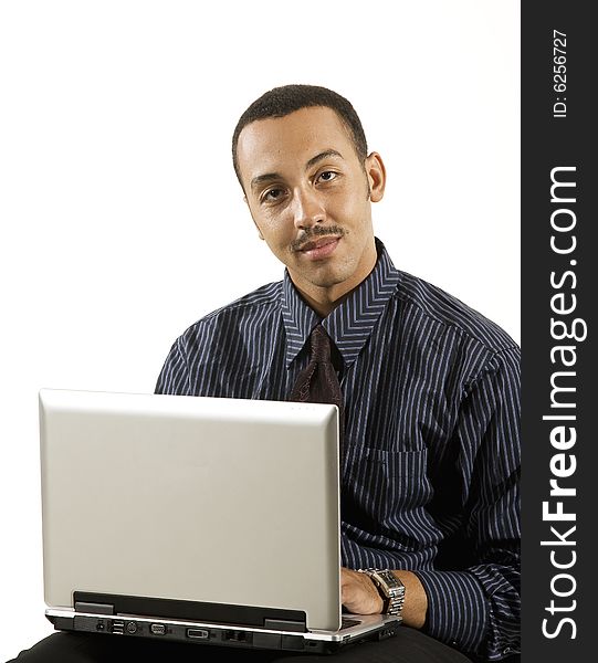 A young professional African-American male working on a laptop. A young professional African-American male working on a laptop.