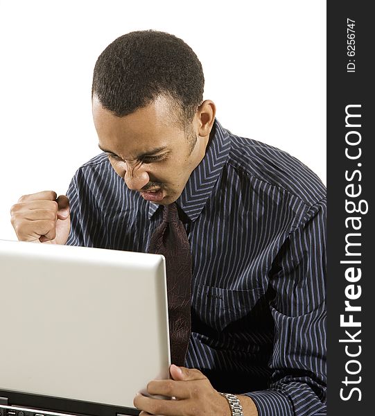 A young professional African-American male working on a laptop. A young professional African-American male working on a laptop.