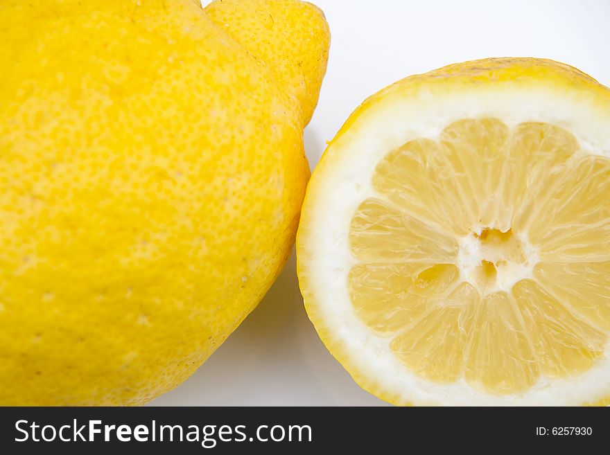 Macro of one and a half a lemon on white dish. Macro of one and a half a lemon on white dish