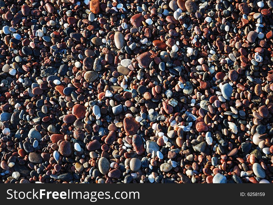 Colourful pebbles on a shore in morning sun. Colourful pebbles on a shore in morning sun