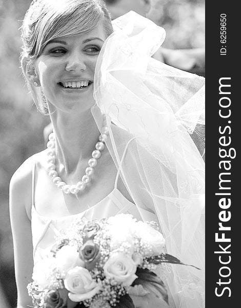 Young beautiful bride with flowers outdoor shot