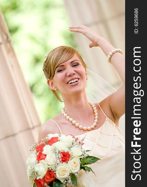 Young beautiful bride with flowers outdoor shot