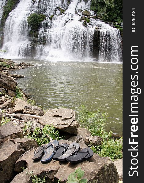 Sandals left on the shore near a waterfall. Sandals left on the shore near a waterfall.