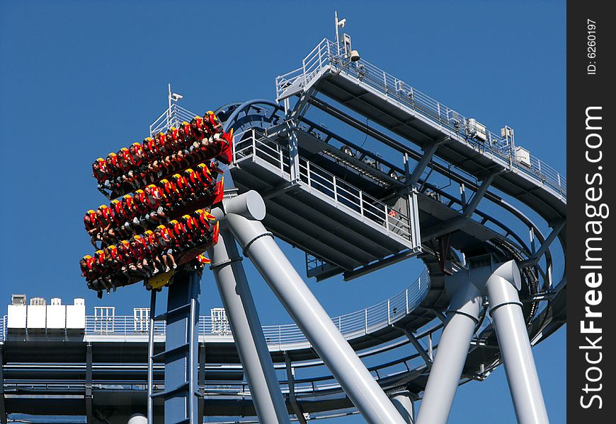 Blue twisted roller coaster track with beam support. People suspended. Blue twisted roller coaster track with beam support. People suspended.