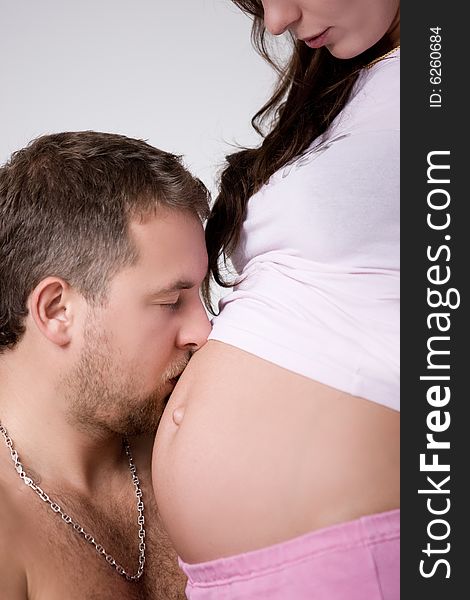 Man is kissing the stomach of the pregnant woman. Man is kissing the stomach of the pregnant woman