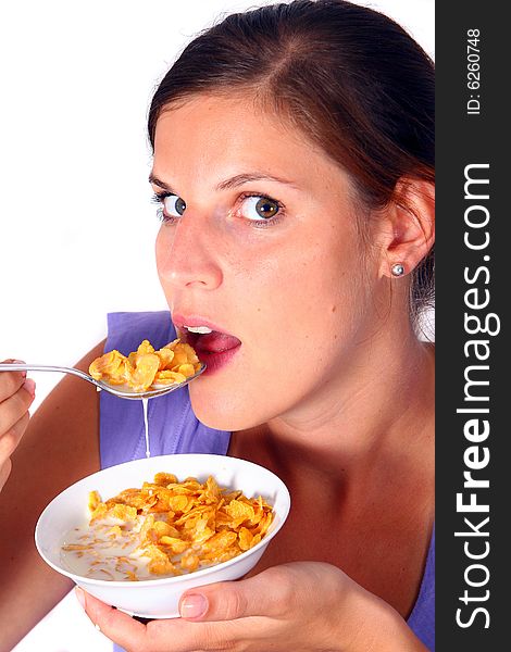 A young woman enjoys her crunchy cornflakes. Isolated over white. A young woman enjoys her crunchy cornflakes. Isolated over white.