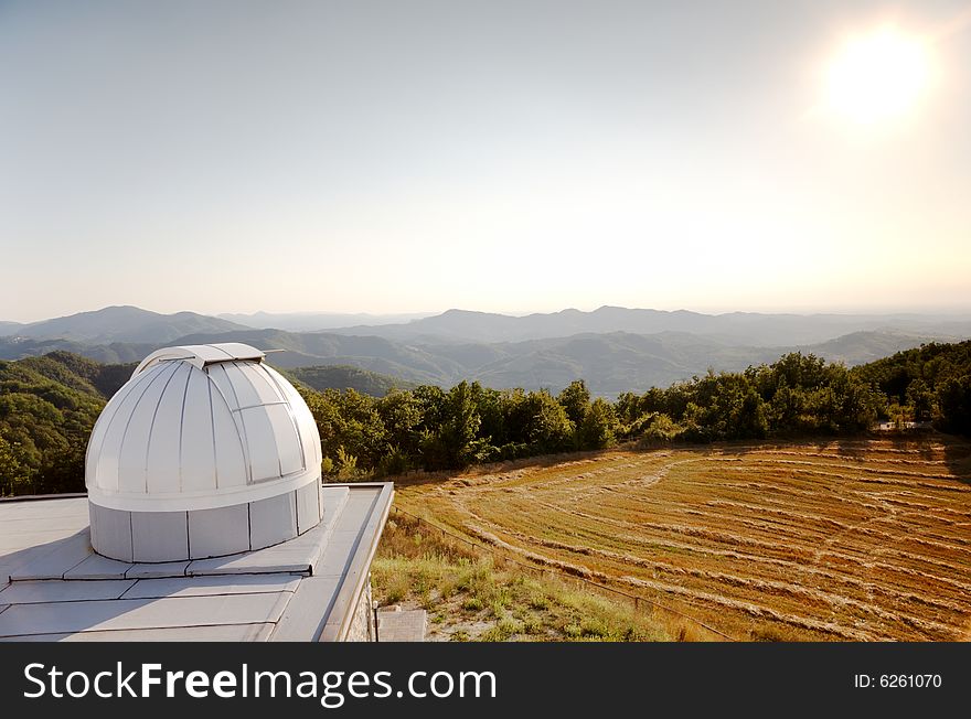 White dome of a small astronomical observatory on the top of a hill in italian countryside.