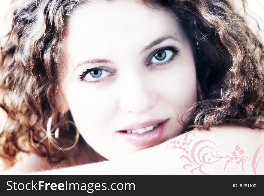 Light portrait of beautiful female with decor details on her shoulder