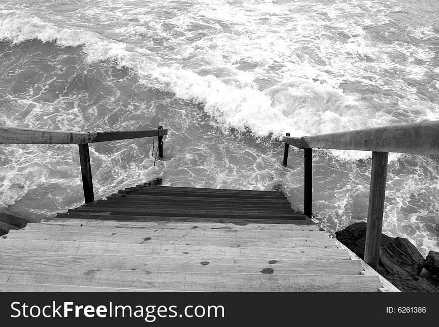 Black and white of stairs leading into the ocean. Black and white of stairs leading into the ocean