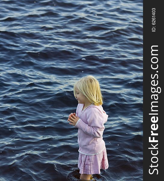 Girl in pink wading through the waters of Island Lake in Northern Minnesota.