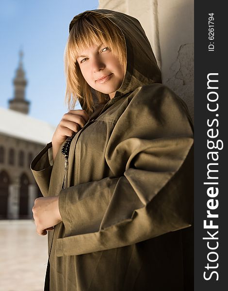 Mysterious girl in cassock and hood is looking