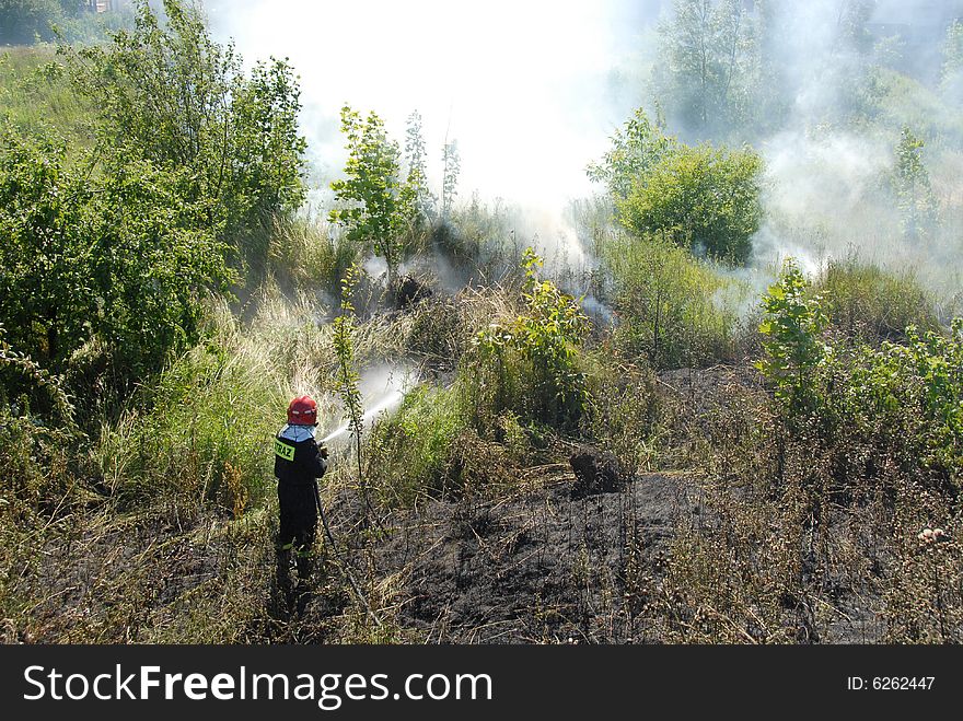 Firefighters using a hose reel jet on a heath fire. Firefighters using a hose reel jet on a heath fire
