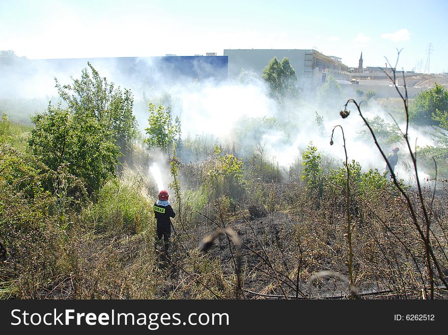 Firefighters using a hose reel jet on a heath fire. Firefighters using a hose reel jet on a heath fire