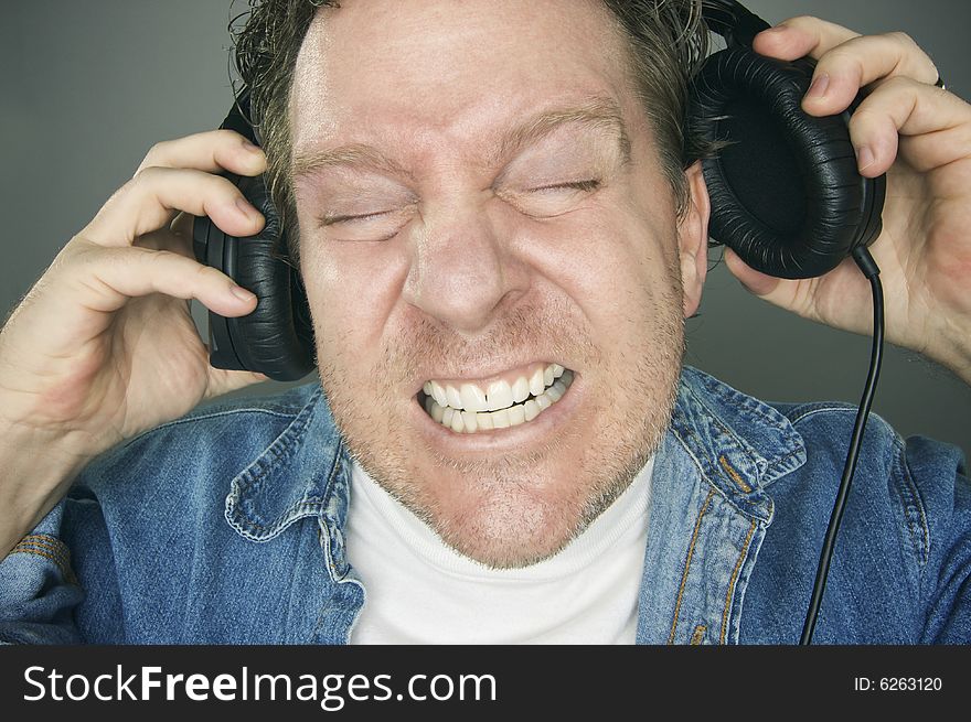 Shocked Man Desperately Pulling His Headphones Off. Shocked Man Desperately Pulling His Headphones Off.