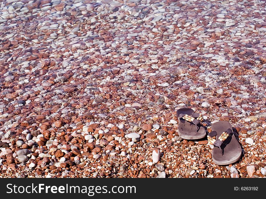 Gravel beach with flip-flops