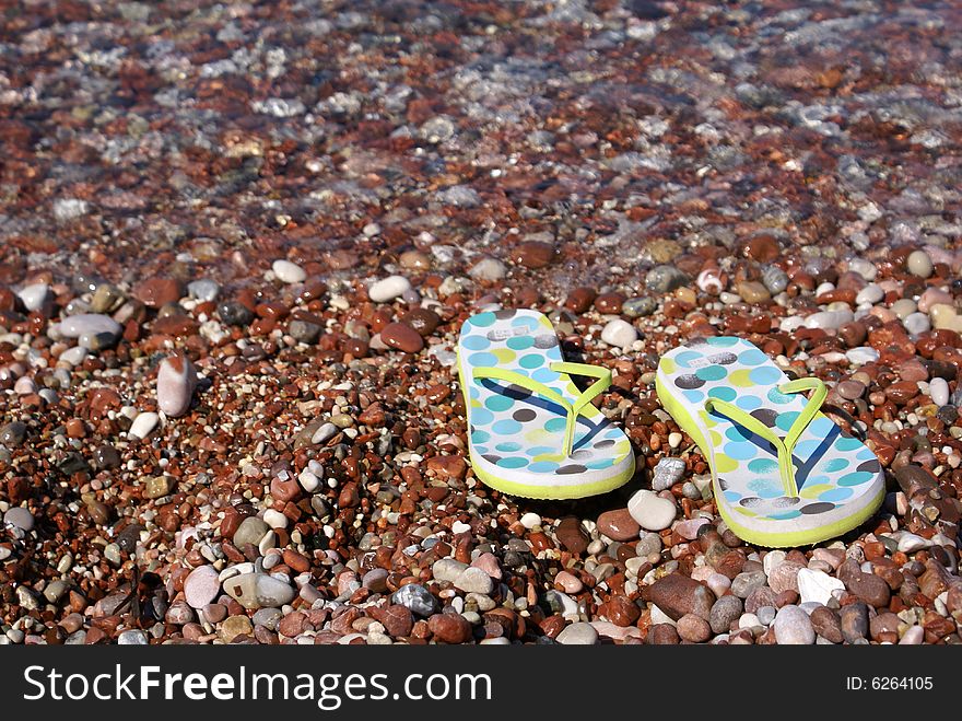 Gravel beach with flip-flops