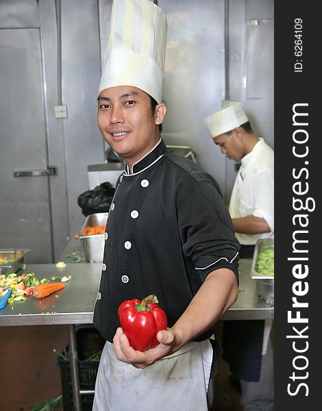Chef at work holding red pepper or capsicum