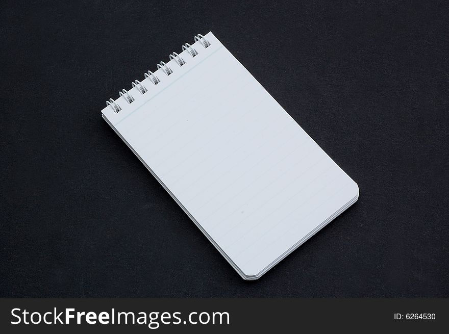 Small notepad isolated on a black background