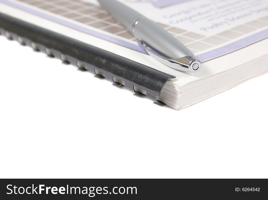 Notebook and a silver pen isolated on white. Notebook and a silver pen isolated on white