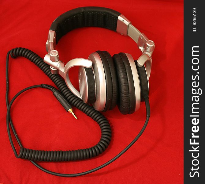 Stereo headphones with cord on a red velvet backdrop