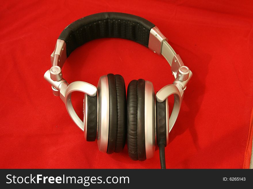 Stereo headphones with cord on a red velvet backdrop