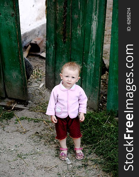 Portrait of a small girl on a background of fence. Portrait of a small girl on a background of fence