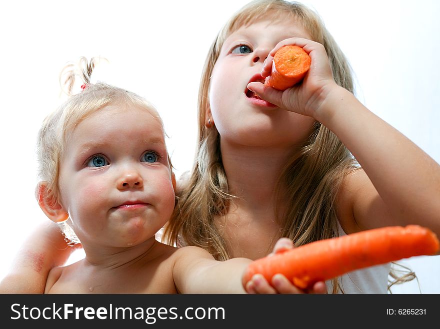 An image of two sisters eating carrots