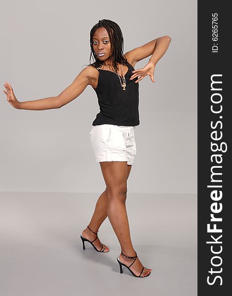 Attractive young African girl posing, full length in white skirt, dark top