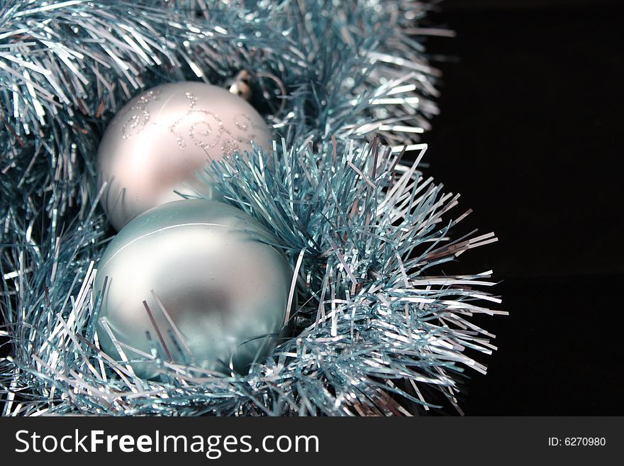 A blue and silver Christmas Tree decoration bauble against tinsel. A blue and silver Christmas Tree decoration bauble against tinsel