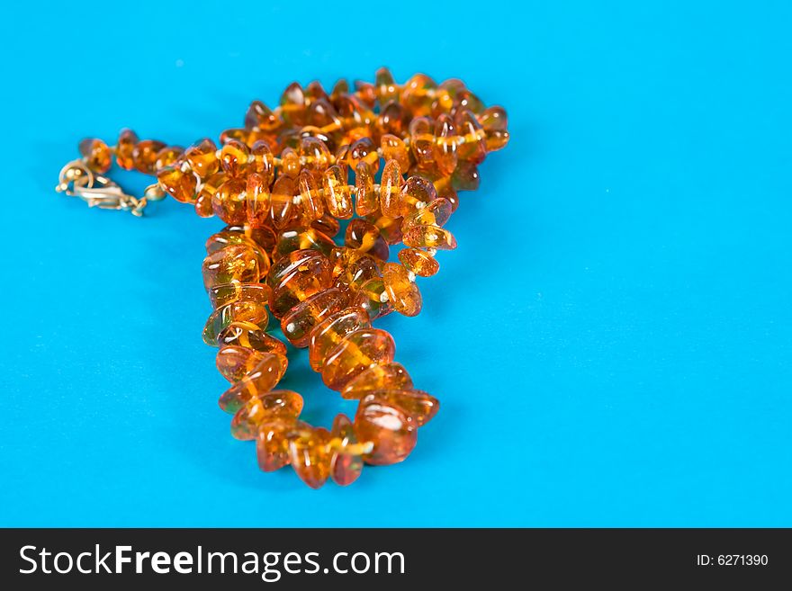 Amber necklace on blue background