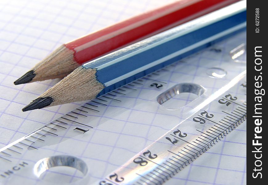 Two pencils and a ruler on the workbook page. Two pencils and a ruler on the workbook page