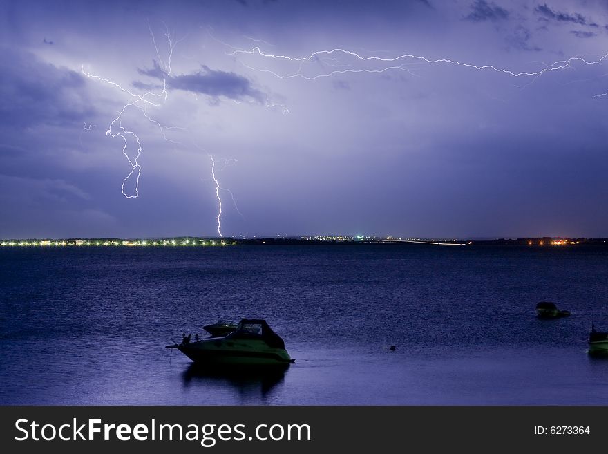 The lightning runs on the sky with a ship in the forefront