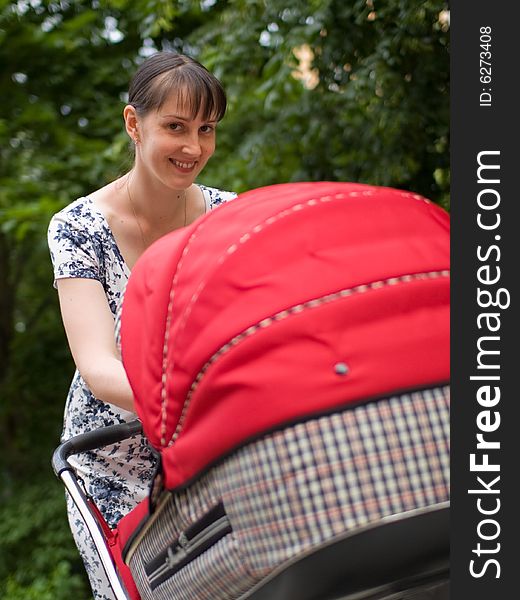 Young woman with red baby carriage. Young woman with red baby carriage