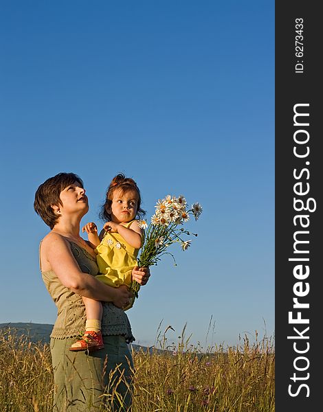 Mother and her girl walking on the meadow in summer day. Mother and her girl walking on the meadow in summer day