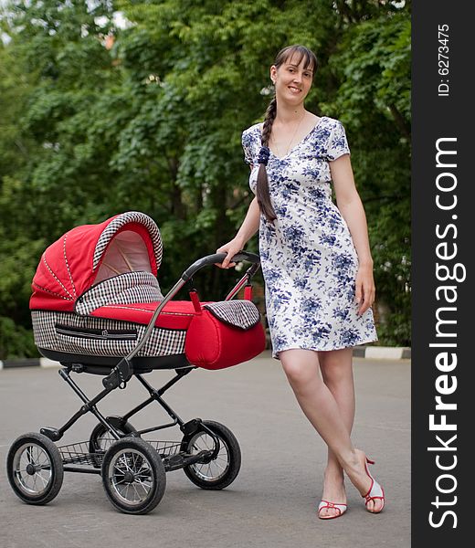 Young woman with red baby carriage. Young woman with red baby carriage