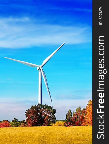 Wind turbine in autumnal landscape with blue sky. Wind turbine in autumnal landscape with blue sky