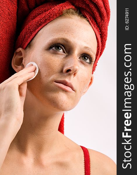 Studio portrait of a beautiful girl who is using a cotton pad on her face. Studio portrait of a beautiful girl who is using a cotton pad on her face