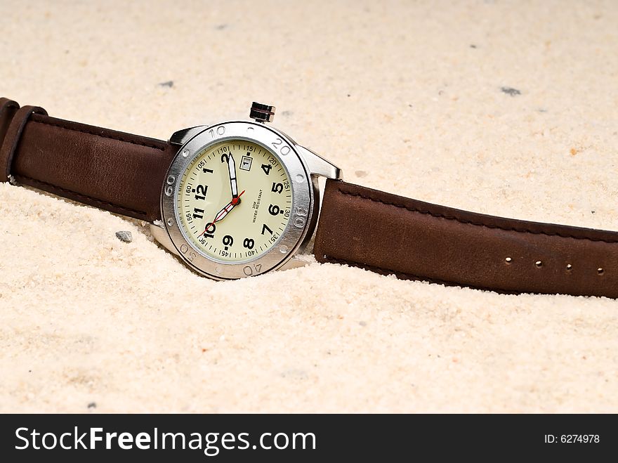 A watch in sand representing The Sands of Time
