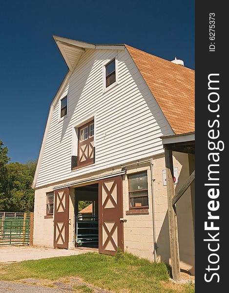 A view of a classic gambrel style country barn on a small dairy farm. A view of a classic gambrel style country barn on a small dairy farm.