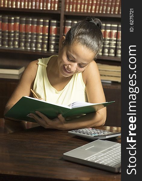 Woman in office smiling as she looks at notebook. Vertically framed photo. Woman in office smiling as she looks at notebook. Vertically framed photo.