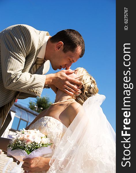 Young bride and groom kissing outdoor. Young bride and groom kissing outdoor