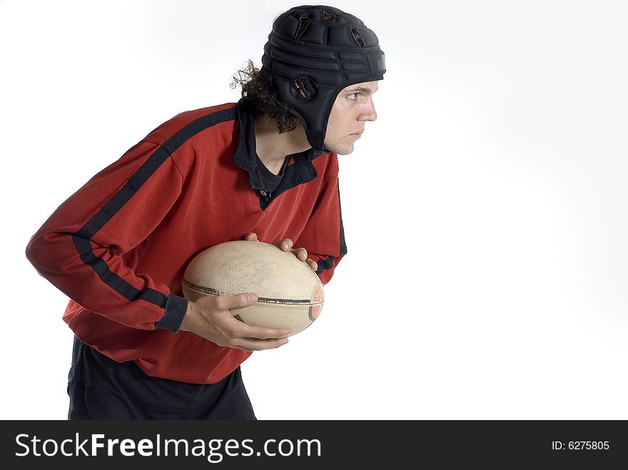 A rugby player holding a ball in his hands. He has his eyes focused forward.  Horizontally framed shot. A rugby player holding a ball in his hands. He has his eyes focused forward.  Horizontally framed shot.